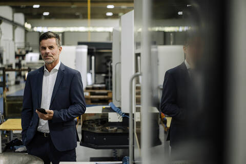 Portrait of a confident businessman in a factory stock photo