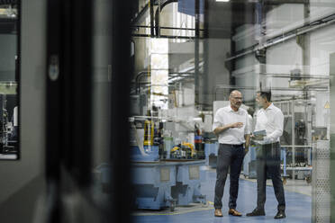 Two businessmen talking in a factory - KNSF07922