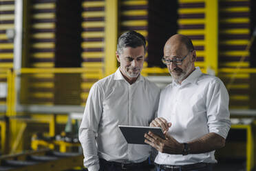 Two businessmen using tablet in a factory - KNSF07924