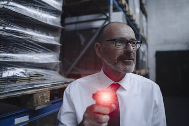Mann mit leuchtendem Scanner in Fabrikhalle - KNSF07927