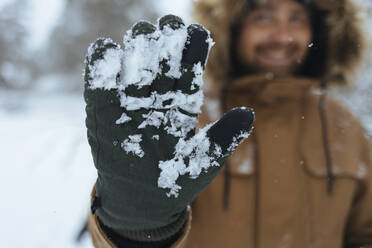 Grüner Handschuh mit Schnee, Nahaufnahme - KNTF04425