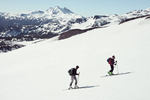 Männlich und weiblich Skifahren mit Bergen im Hintergrund - CAVF76119