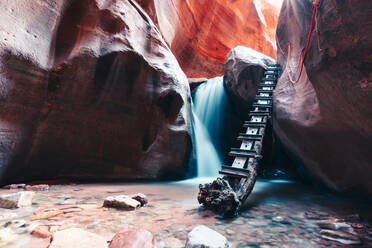 Langzeitbelichtung eines Wasserfalls, der über eine Felsstufe im Slot Canyon fließt - CAVF76189