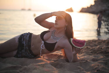 Schöne junge Frau mit einer Wassermelone an einem Strand - CAVF76216