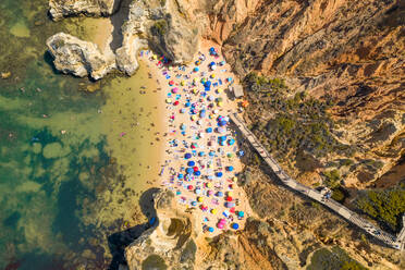 Luftaufnahme von oben von Menschen, die den Sommer in Praia do Camilo, Portugal, genießen. - AAEF07025