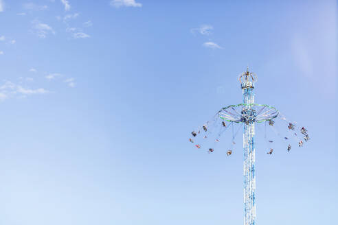 Germany, Bavaria, Munich, Low angle view of Bayern Tower chain swing ride standing against clear sky - MMAF01285