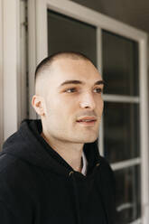 Portrait of pensive young man with shaved head - KMKF01229