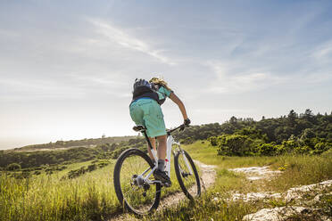 Mountainbikerin fährt einen schmalen Pfad hinunter, Santa Cruz, Kalifornien, USA - MSUF00230