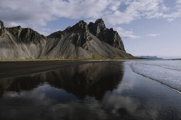 Dramatischer blauer Himmel und Bergspiegelung am Strand in Island - CAVF76321