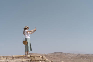 Junge Frau beim Fotografieren mit dem Smartphone, Ouarzazate, Marokko - AFVF05580