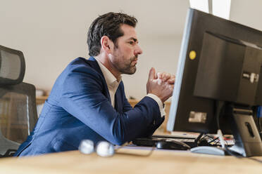 Porträt eines Geschäftsmannes am Schreibtisch im Büro - DIGF09467