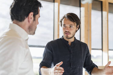 Two businessmen talking in office - DIGF09479