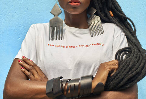 Portrait of woman with long dreadlocks wearing a T-shirt with the 'You were never my boyfriend' message on it in front of turquoise wall - VEGF01691