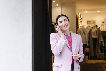 Stylish woman in pink jacket using talking on the - VYF00056