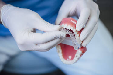 Close-up of dentist working on dentures - JCMF00416