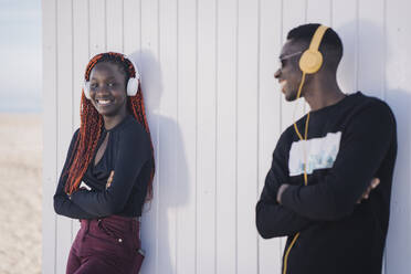 Porträt eines glücklichen Teenagers und eines jungen Mannes mit Kopfhörern im Freien - MPPF00607