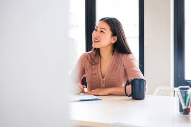 Smiling business professional listening in meeting at board room - CAVF76457