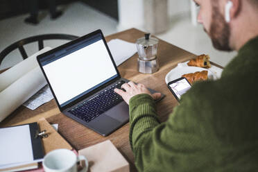 High angle view entrepreneur using laptop at home office - MASF16881