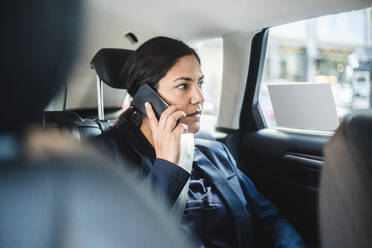 Geschäftsfrau, die im Auto sitzend telefoniert - MASF16948