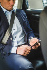 Mature businessman using mobile phone while sitting in car - MASF16954