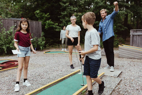 Familie in voller Länge beim Minigolfspielen im Hinterhof - MASF17053