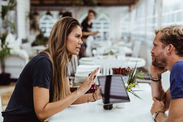 Weibliche Besitzerin nimmt die Bestellung eines Kunden auf, während sie ein digitales Tablet im Restaurant benutzt - MASF17099