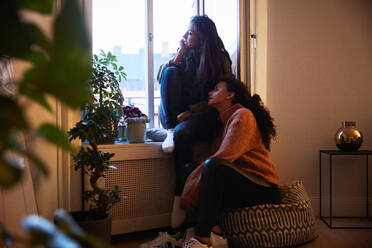 Lesbisches Paar in voller Länge am Fenster einer Mietwohnung im Urlaub - MASF17125