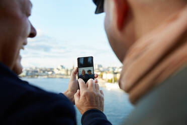 Schwules Paar macht Selfie mit Handy gegen den Himmel in der Stadt - MASF17146