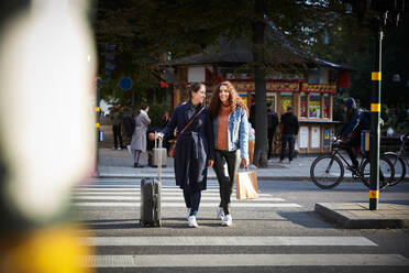 Frauen in voller Länge mit Taschen auf dem Zebrastreifen in der Stadt - MASF17147