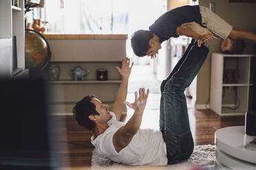 Glücklicher Vater spielt, während er seinen Sohn in der Luft auf den Beinen hält - MASF17189