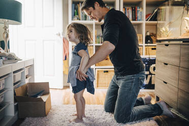 Vater zieht Tochter im Wohnzimmer an - MASF17239