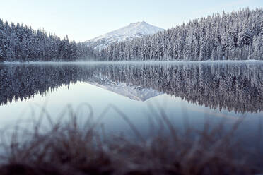 Malerischer See im Winter mit schneebedeckten Bäumen und Bergen - CAVF76599