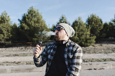 Young man smoking with a electronic cigarette - CAVF76685
