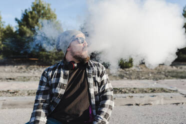 Young man smoking with a electronic cigarette - CAVF76687