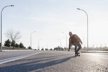 Junger Mann auf dem Skateboard auf der Straße - CAVF76690