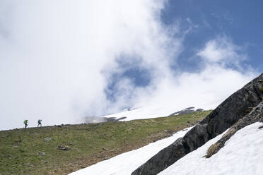 Two female mountaineers hiking on Mt. Baker, Washington - CAVF76724