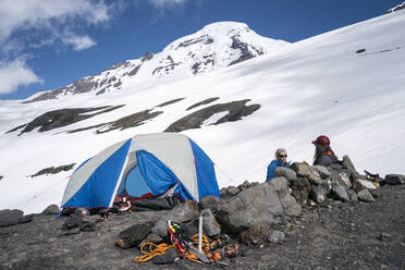 Zwei Bergsteigerinnen unterhalten sich in der Nähe ihres Zeltes am Mount Baker - CAVF76746