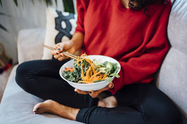 Brunette woman eating a healthy green salad. - CAVF76976