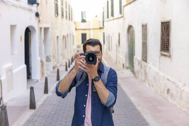 Mann beim Fotografieren mit Kamera in der Stadt, Mao, Menorca, Spanien - JPTF00475