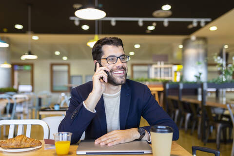 Portrait of happy businessman on the phone in a coffee shop stock photo