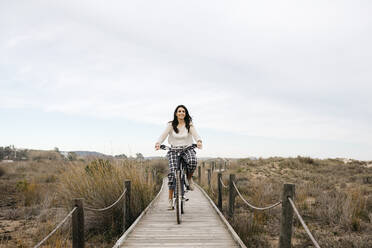 Frau fährt Fahrrad auf einer Promenade auf dem Lande - JRFF04130