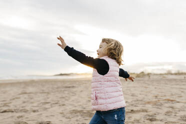 Happy girl playing on the beach at sunset - JRFF04164