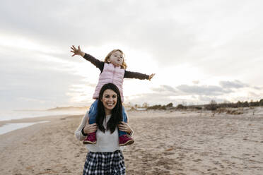 Glückliche Mutter trägt Tochter auf den Schultern am Strand bei Sonnenuntergang - JRFF04170