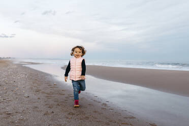 Glückliches Mädchen läuft bei Sonnenuntergang am Strand - JRFF04182