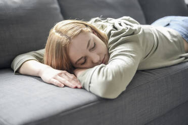 Portrait of blond young woman napping on the couch - BFRF02198