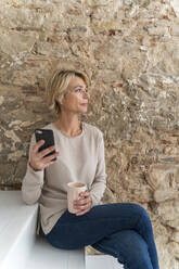 Mature businesswoman having a break sitting on stairs - AFVF05645