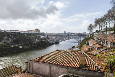 Portugal, Porto, Altstadthäuser entlang des Flusses Douro mit der Brücke Dom Luis I im Hintergrund - LJF01384