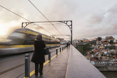Portugal, Porto, Unscharfe Bewegung eines U-Bahn-Zugs, der in der Abenddämmerung eine Hochbahnstrecke passiert - LJF01390