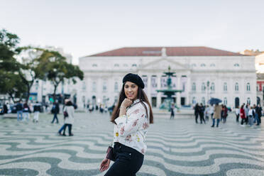 Young female traveller wearing a beret and posing at Rossio square, Lisbon, Portugal - DCRF00120