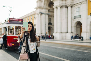 Junge Reisende macht ein Selfie am Praca do Comercio, Lissabon, Portugal - DCRF00126